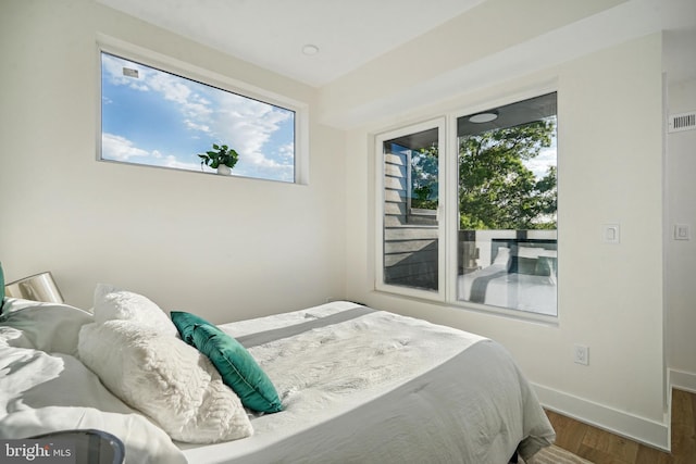 bedroom with dark wood-type flooring and multiple windows