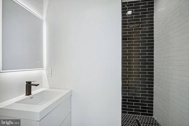 bathroom with vanity and tiled shower