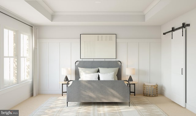 carpeted bedroom featuring a tray ceiling, a barn door, and crown molding