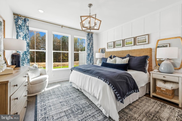 bedroom featuring wood-type flooring and an inviting chandelier