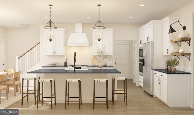 kitchen featuring sink, light hardwood / wood-style flooring, premium range hood, pendant lighting, and white cabinets