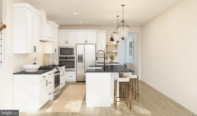 kitchen featuring a kitchen island with sink, hanging light fixtures, light hardwood / wood-style floors, white cabinetry, and stainless steel appliances