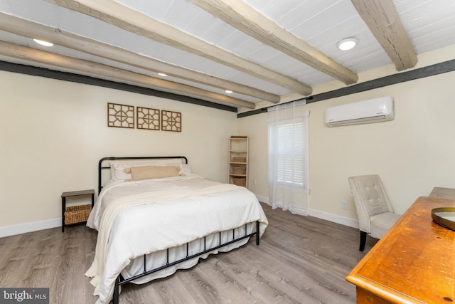 bedroom featuring beamed ceiling, wood-type flooring, and a wall mounted air conditioner