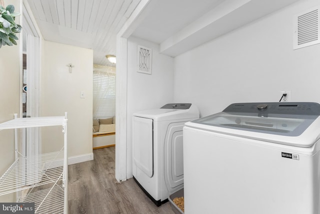 clothes washing area featuring washing machine and dryer and hardwood / wood-style floors