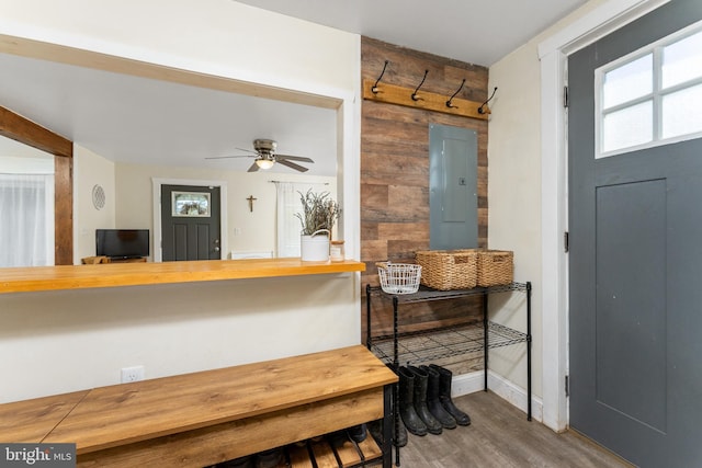 interior space with ceiling fan, wood-type flooring, and electric panel