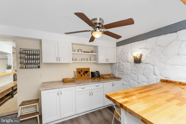 kitchen featuring white cabinets, butcher block countertops, ceiling fan, and dark wood-type flooring