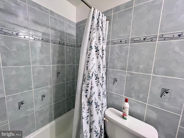 bathroom featuring toilet and shower / tub combo with curtain