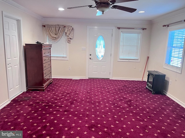 carpeted entryway featuring crown molding and ceiling fan