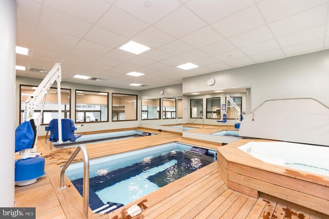 view of swimming pool featuring an indoor hot tub