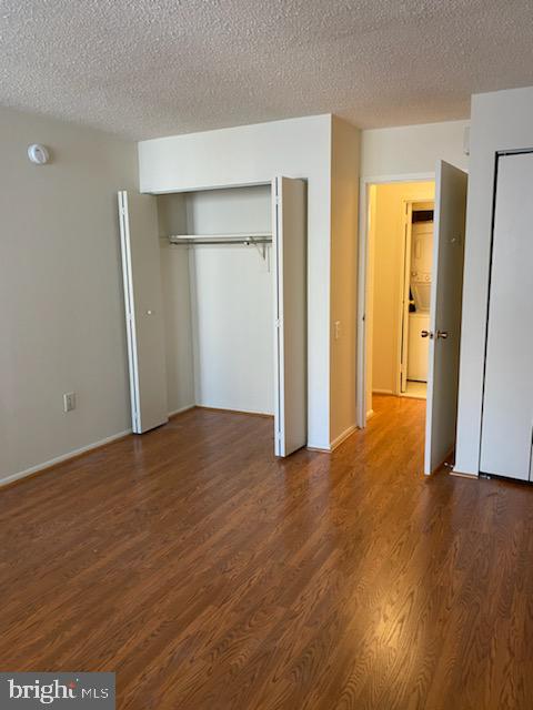 unfurnished bedroom featuring dark hardwood / wood-style flooring and a textured ceiling