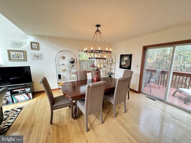 dining area featuring light hardwood / wood-style flooring and a chandelier