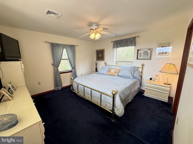 carpeted bedroom with ceiling fan and multiple windows