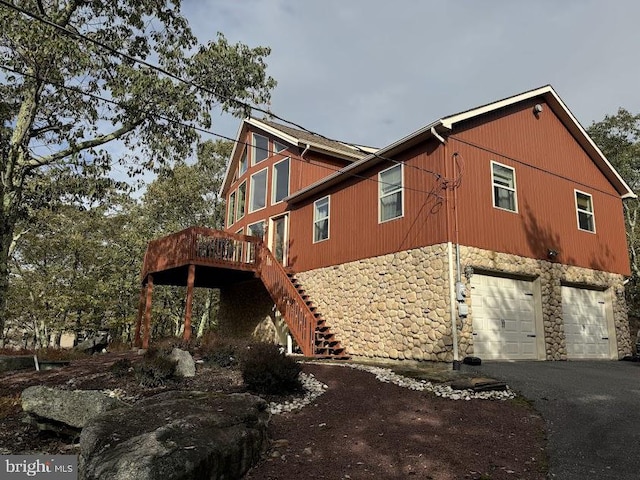 view of home's exterior featuring a garage and a wooden deck