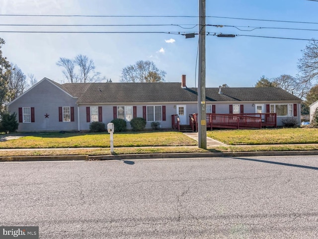 single story home featuring a front yard and a deck