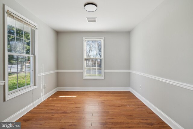 spare room with plenty of natural light and hardwood / wood-style floors