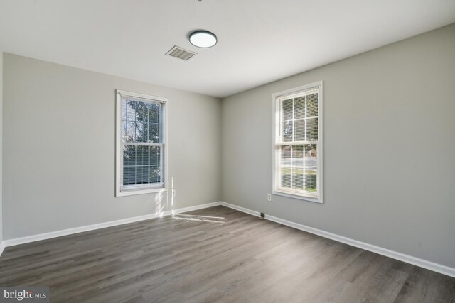 empty room featuring dark hardwood / wood-style floors and a healthy amount of sunlight