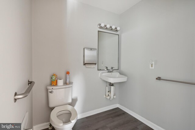 bathroom with hardwood / wood-style flooring and toilet