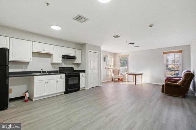 kitchen with black appliances, light hardwood / wood-style floors, and white cabinets