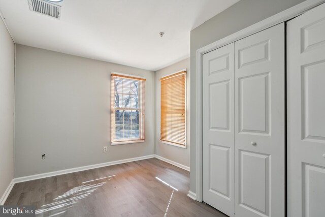 unfurnished bedroom with light hardwood / wood-style flooring and a closet