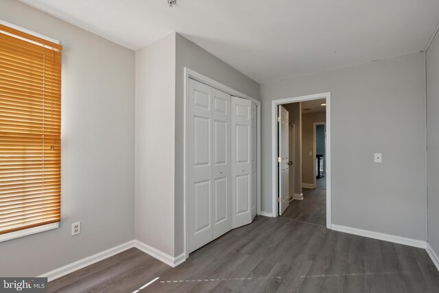 unfurnished bedroom featuring a closet and dark hardwood / wood-style floors