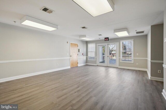 empty room with hardwood / wood-style flooring and french doors