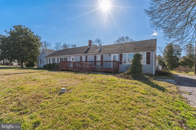 ranch-style house featuring a front yard and a deck