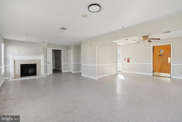 unfurnished living room with ceiling fan and a fireplace