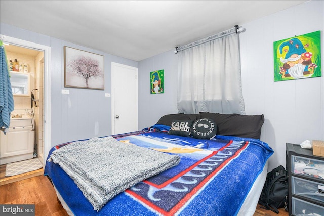 bedroom with hardwood / wood-style floors and ensuite bathroom