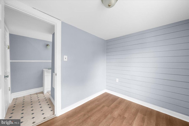 interior space with light hardwood / wood-style floors and wooden walls