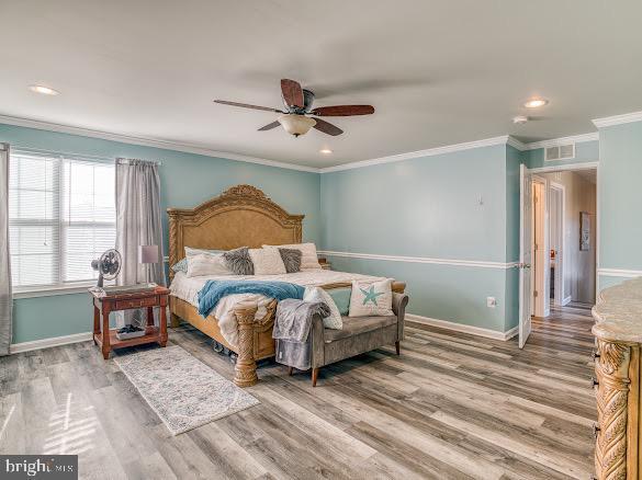 bedroom featuring wood-type flooring, ceiling fan, and ornamental molding