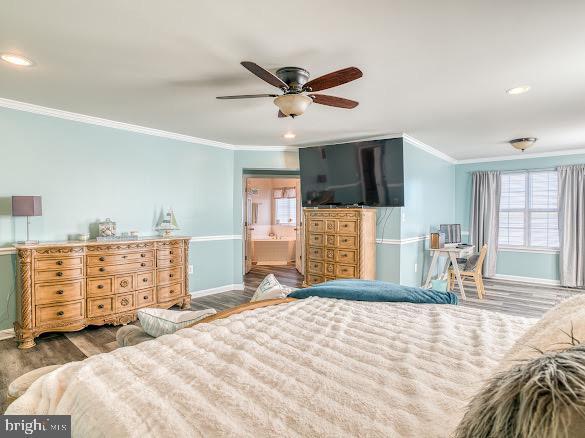 bedroom featuring hardwood / wood-style floors, ceiling fan, ornamental molding, and connected bathroom