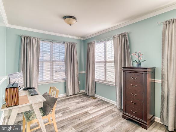 office with crown molding and light hardwood / wood-style floors