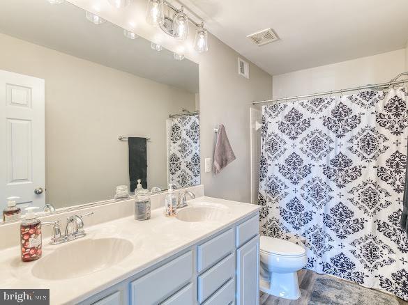 bathroom featuring a shower with curtain, vanity, and toilet