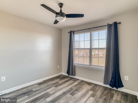 empty room featuring ceiling fan and hardwood / wood-style floors