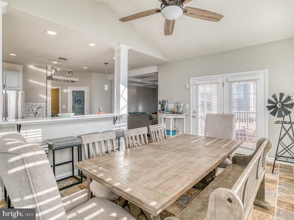 dining area featuring vaulted ceiling, ceiling fan, and sink