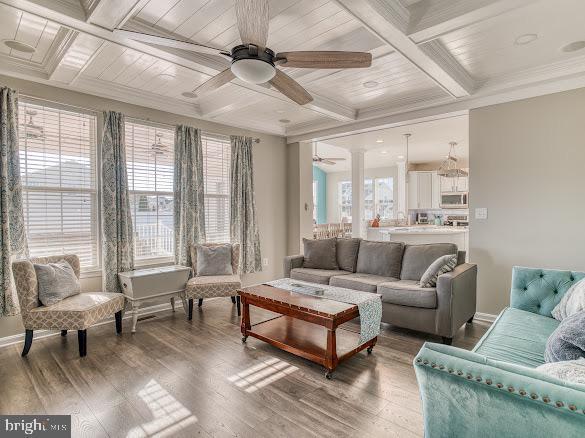 living room with coffered ceiling, hardwood / wood-style flooring, ceiling fan, ornamental molding, and beam ceiling