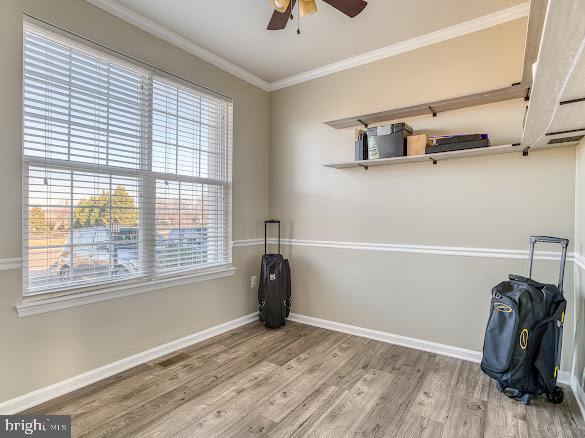 unfurnished room with ornamental molding, ceiling fan, a healthy amount of sunlight, and wood-type flooring