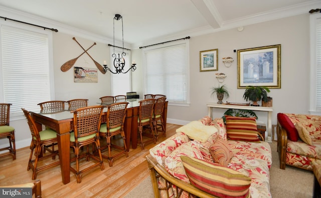 dining space with ornamental molding, a notable chandelier, and light hardwood / wood-style floors