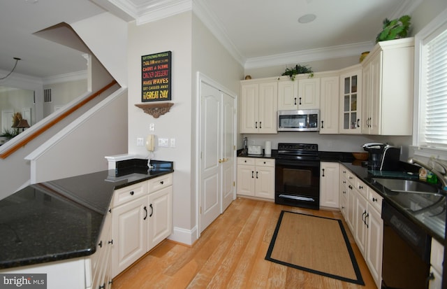 kitchen with sink, crown molding, white cabinetry, black appliances, and light hardwood / wood-style floors