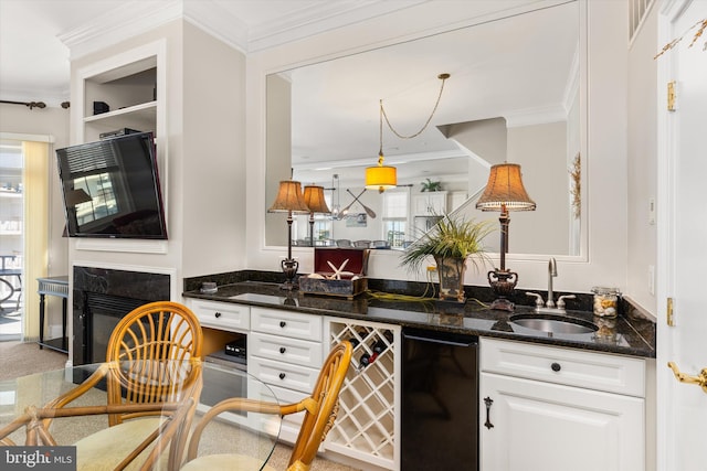 9 134th St Unit 9B, Ocean City, MD 21842 - kitchen featuring dark stone counters, a sink, white cabinetry, and ornamental molding