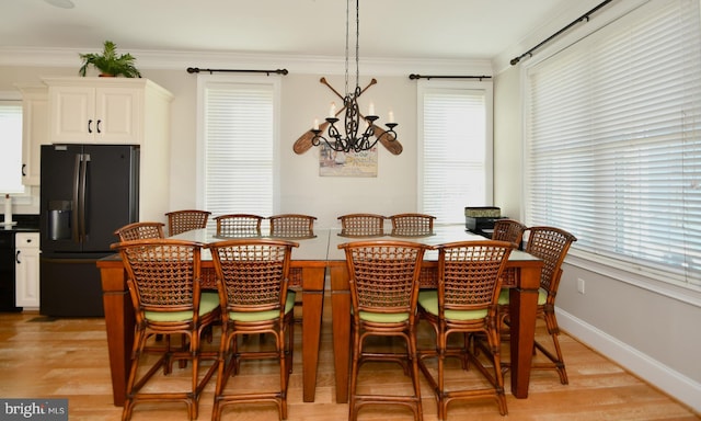9 134th St Unit 9B, Ocean City, MD 21842 - dining area with light wood-style flooring, baseboards, ornamental molding, and an inviting chandelier