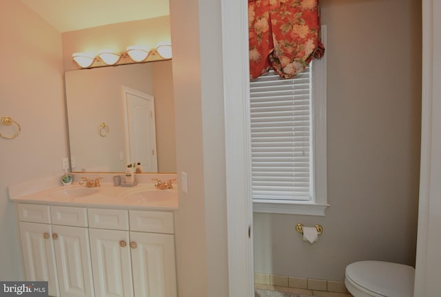 bathroom featuring a healthy amount of sunlight, vanity, and toilet