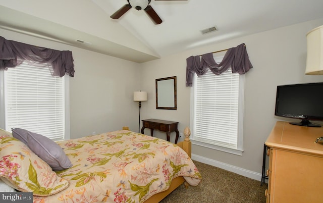 bedroom with multiple windows, vaulted ceiling, ceiling fan, and dark colored carpet