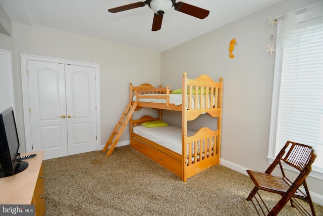 bedroom featuring multiple windows, a closet, ceiling fan, and carpet