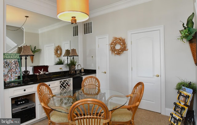 carpeted dining space featuring ornamental molding and sink