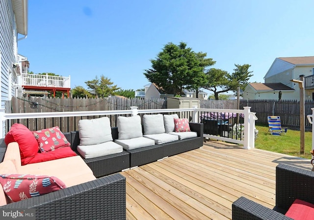 wooden terrace featuring an outdoor hangout area and a lawn