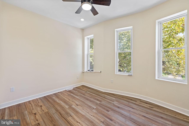 unfurnished room featuring light hardwood / wood-style floors, ceiling fan, and a wealth of natural light