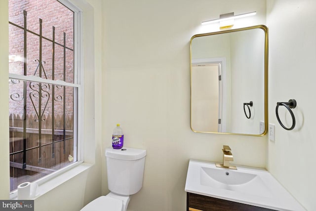 bathroom featuring vanity, toilet, and plenty of natural light