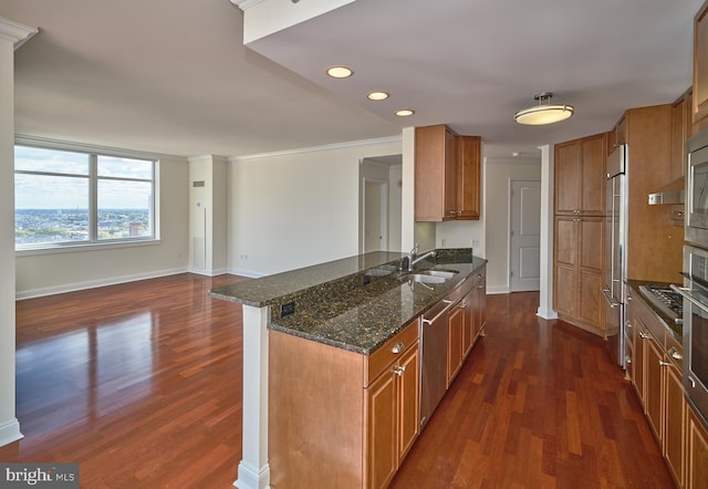 kitchen with dark stone countertops, crown molding, kitchen peninsula, and dark hardwood / wood-style floors