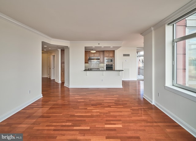 unfurnished living room with a wealth of natural light, ornamental molding, and dark wood-type flooring